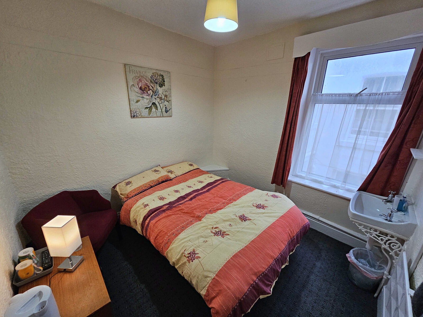 A single bedroom with a sink in the corner