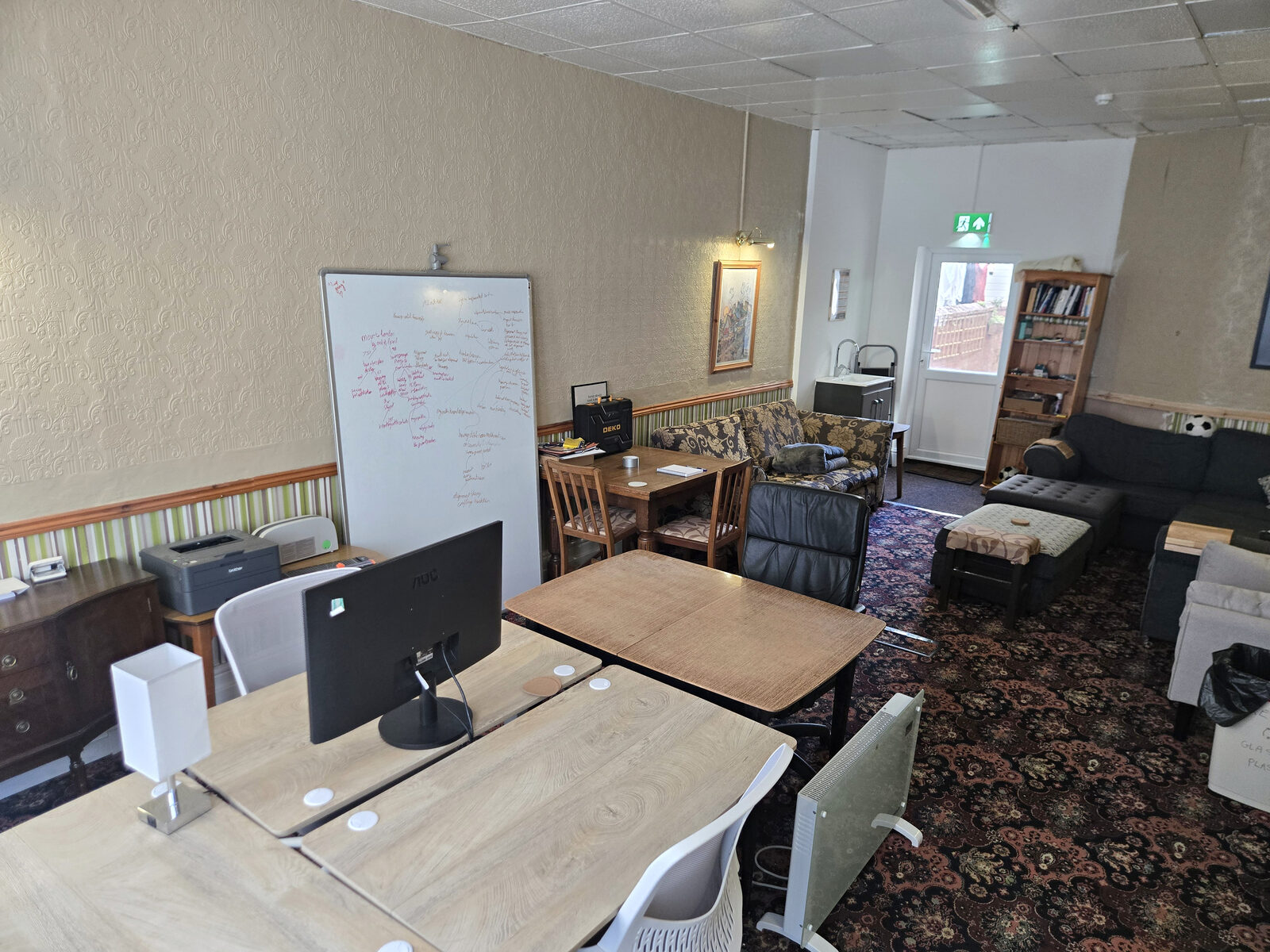 Desks, monitors and a whiteboard set up in the lounge